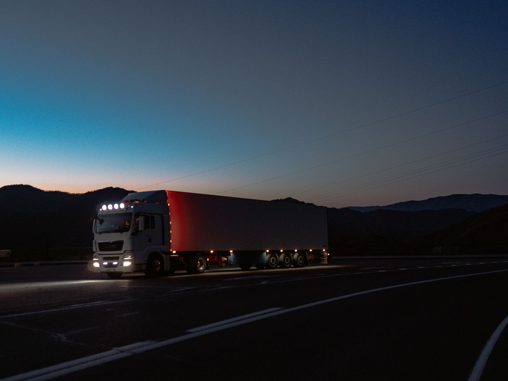 Tow truck arriving at night on a highway to help a stranded driver