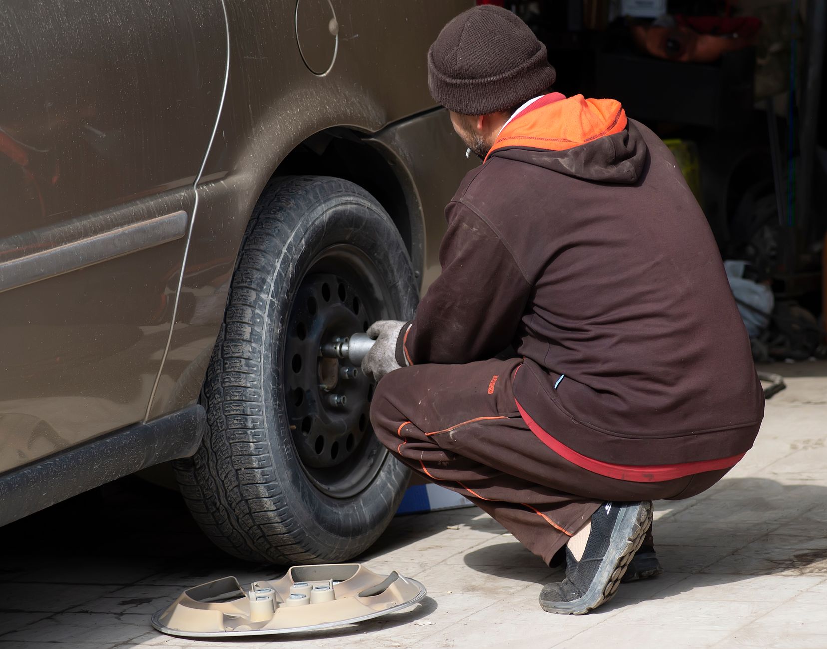 Mechanic changing car wheel in a professional setting