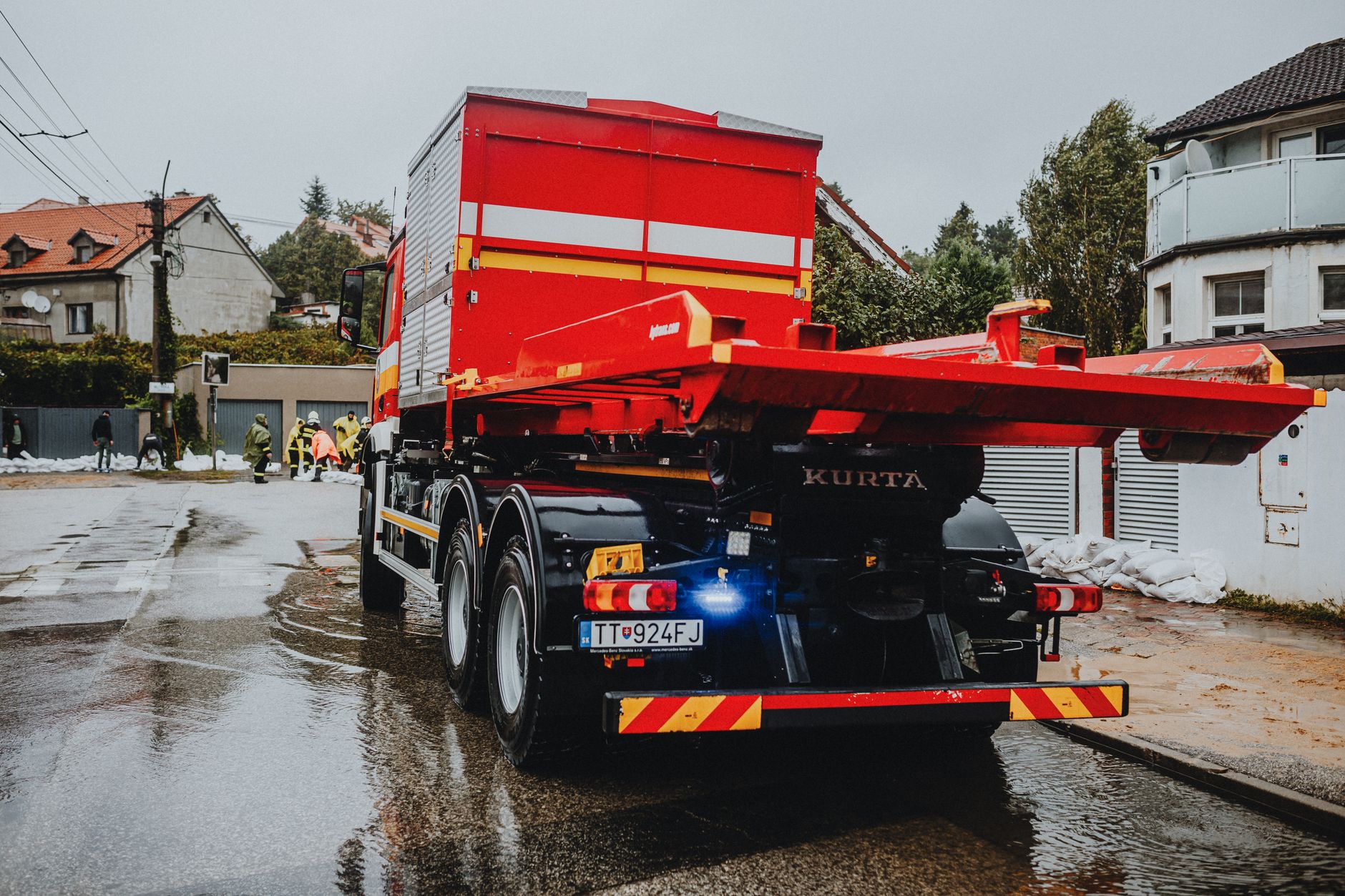 Red tow truck parked on a wet street