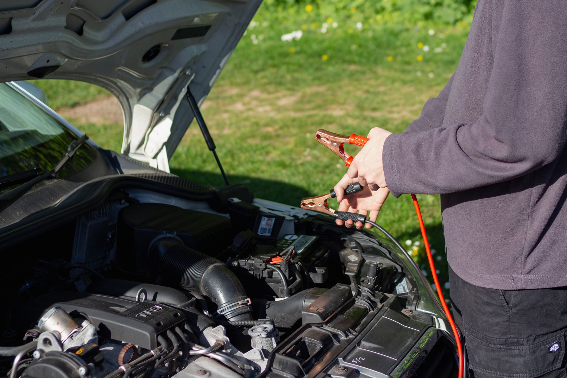 Mechanic holding jumper cables confidently