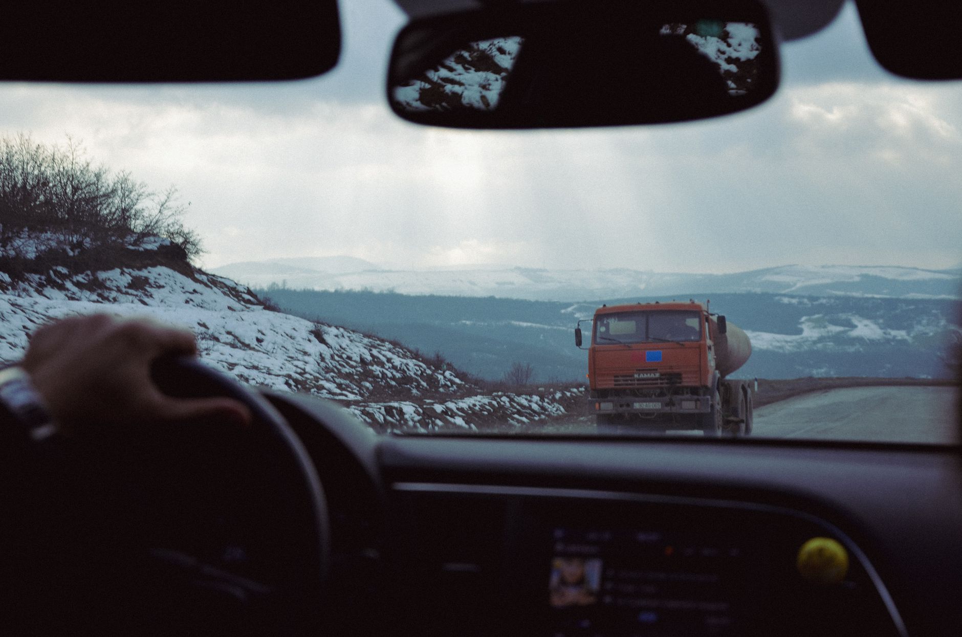 Professional tow truck driver helping a stranded motorist on a snowy road