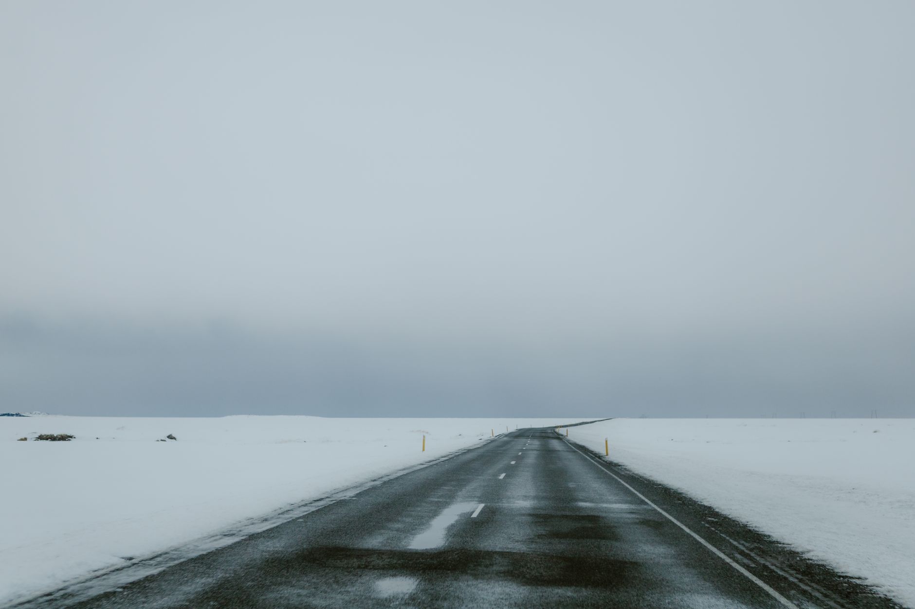 Desolate winter road stretching into the snowy horizon