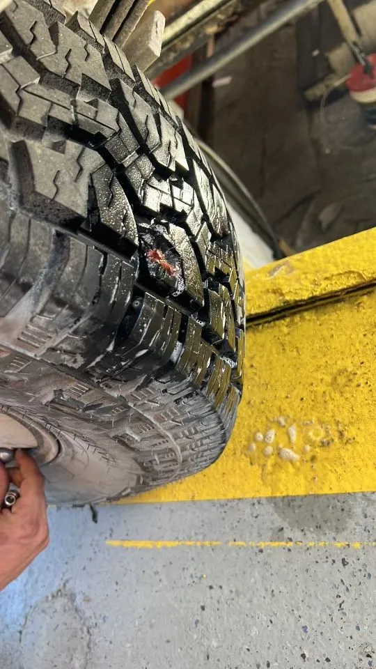A close up of a tire with a hole in it.