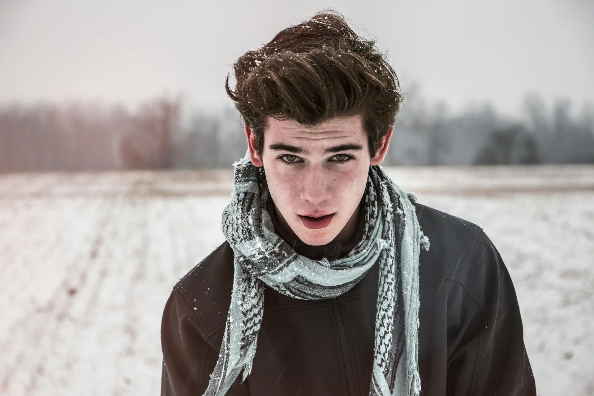 Young man wearing a scarf in the snow