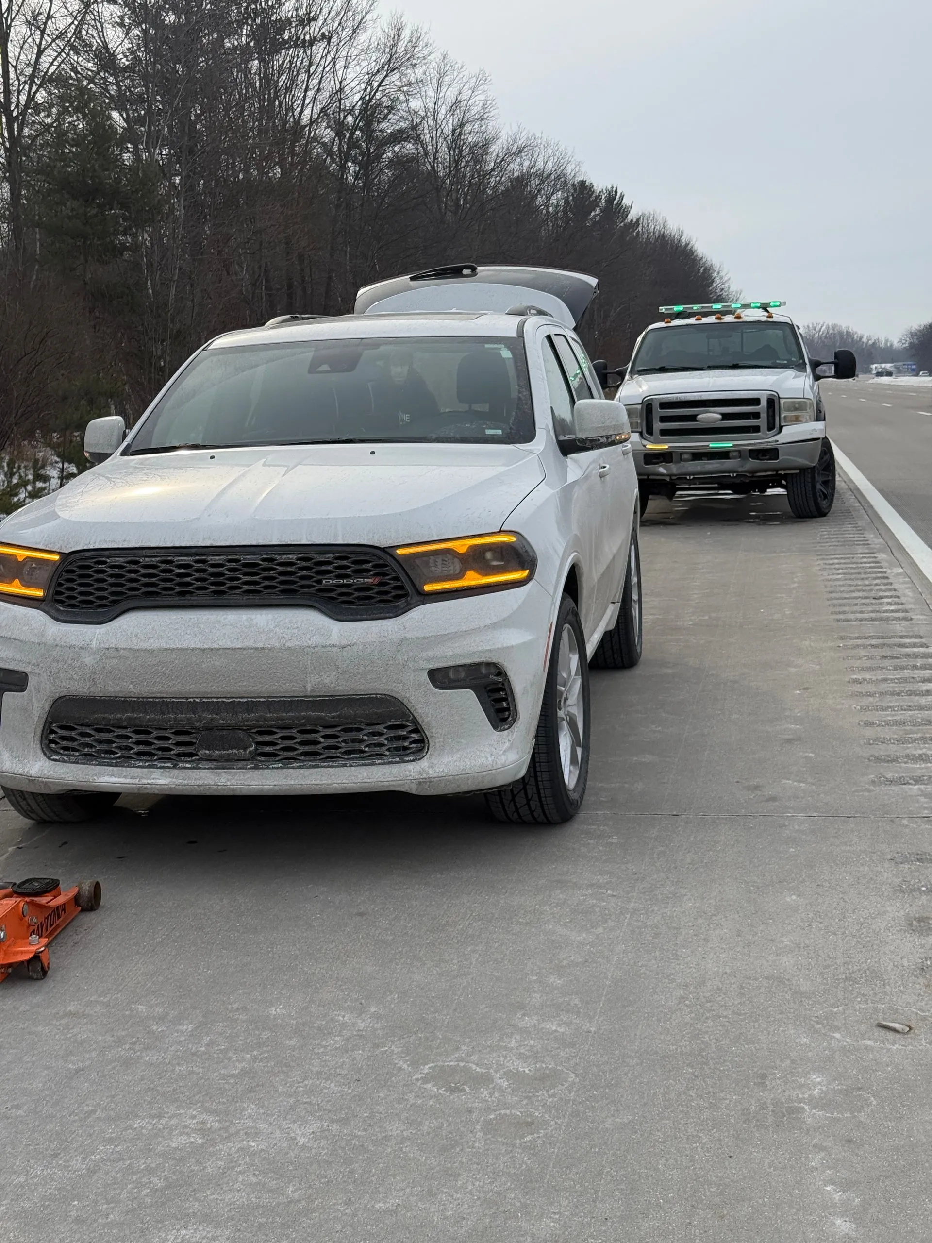 Two white cars are parked on the side of the road.