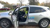 A man is sitting in the driver's seat of a car